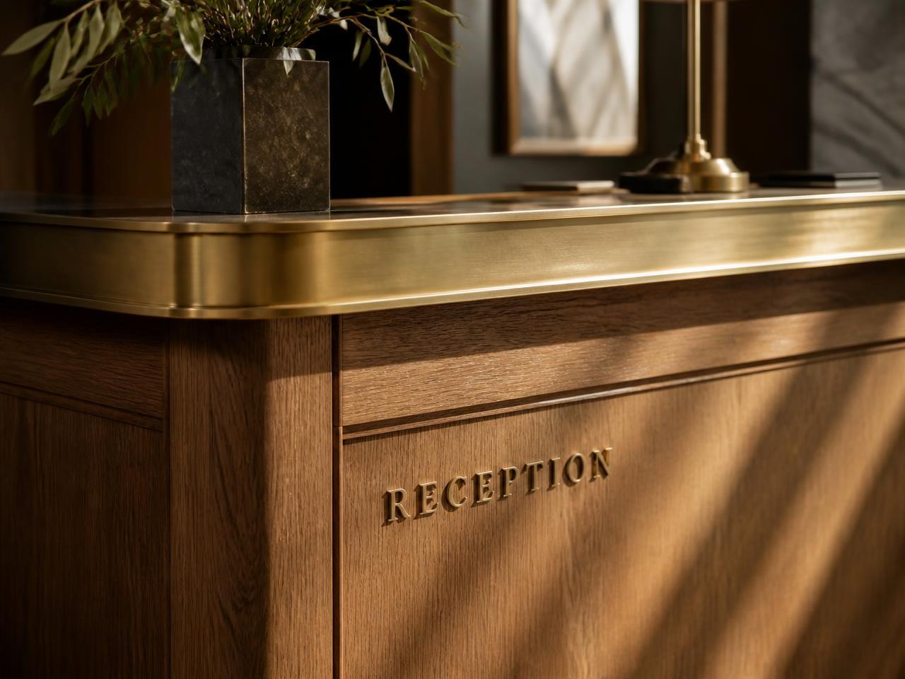 Detail of an elegant hotel reception desk in oak and brass